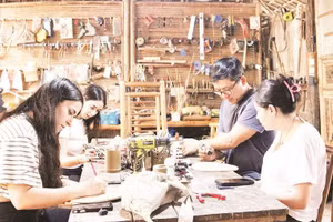 Anh Võ Tấn Tân hướng dẫn khách trải nghiệm làm sản phẩm thủ công mỹ nghệ từ tre.