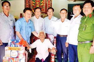 Đại diện cán bộ xã Vĩnh Bình thăm hỏi và trao quà tặng hộ người có công.