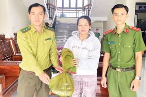 Chị Quách Thị Ánh Như, ngụ ấp Đông Sơn 1, xã Thoại Sơn bàn giao cá thể trăn đất. (Ảnh: Công an An Giang)