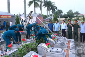 Các đại biểu chứng kiến việc triển khai lấy mẫu hài cốt liệt sĩ.