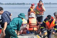 Lực lượng chức năng hỗ trợ người dân ra khỏi khu vực ngập sâu. (Nguồn: Công an thành phố Hà Nội)