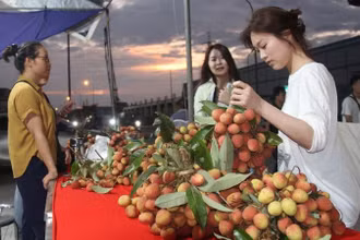 Công nhân khu công nghiệp Nội Hoàng, Bắc Giang trải nghiệm gian hàng vải thiều sau giờ tan ca.