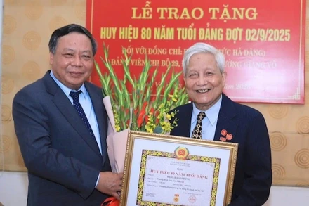 Đồng chí Nguyễn Văn Phong, Phó Bí thư Thường trực Thành ủy Hà Nội trao tặng Huy hiệu 80 năm tuổi Đảng cho nhà báo Hà Đăng. (Ảnh: Quang Thái)