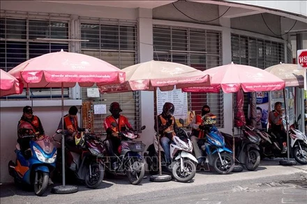 Ảnh minh họa: Các lái xe máy chở khách tránh nắng nóng tại Bangkok, Thái Lan. (Ảnh: THX/TTXVN)