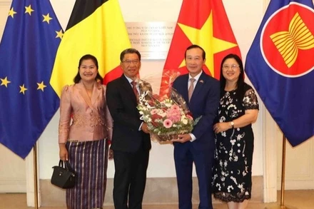 Đại sứ Kingphokeo Phommahaxay (trái) tặng hoa cho Đại sứ Nguyễn Văn Thảo. (Ảnh: HƯƠNG GIANG/TTXVN)