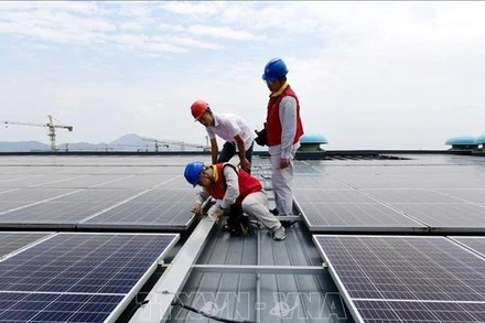 Các kỹ sư kiểm tra hệ thống điện mặt trời được lắp đặt trên mái ở tỉnh Chiết Giang, Trung Quốc. (Ảnh minh họa: China Daily/TTXVN)