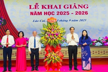 Bí thư Tỉnh ủy Trịnh Xuân Trường tặng hoa chúc mừng nhà trường. (Ảnh: THANH SƠN)