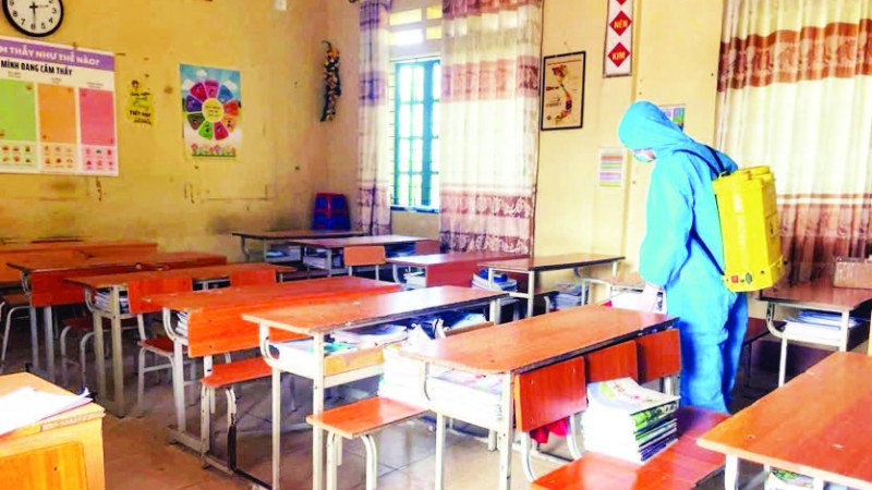 Thực hiện phun khử khuẩn tại trường học có học sinh mắc bệnh. (Ảnh PHƯƠNG THẢO)