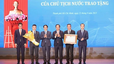 Phó Thủ tướng, Bộ trưởng Ngoại giao Bùi Thanh Sơn thừa ủy quyền của Chủ tịch nước trao tặng Huân chương Lao động hạng Nhất cho Sở Ngoại vụ Thành phố Hồ Chí Minh. (Ảnh: NGÔ TÙNG).
