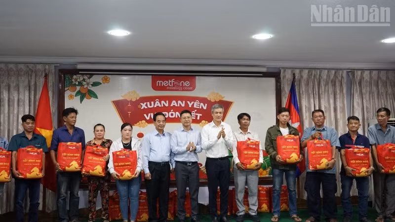 Đại sứ Việt Nam tại Campuchia Nguyễn Minh Vũ cùng đại diện Ban tổ chức trao tặng quà Tết cho bà con gốc Việt có hoàn cảnh khó khăn. (Ảnh: ĐINH TRƯỜNG)