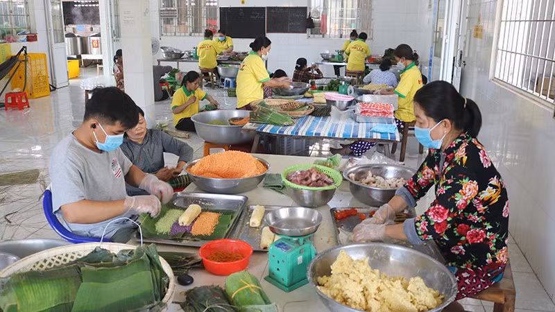 Gói bánh tét 3 màu tại làng nghề bánh tét Trà Cuôn, xã Vinh Kim, tỉnh Vĩnh Long.