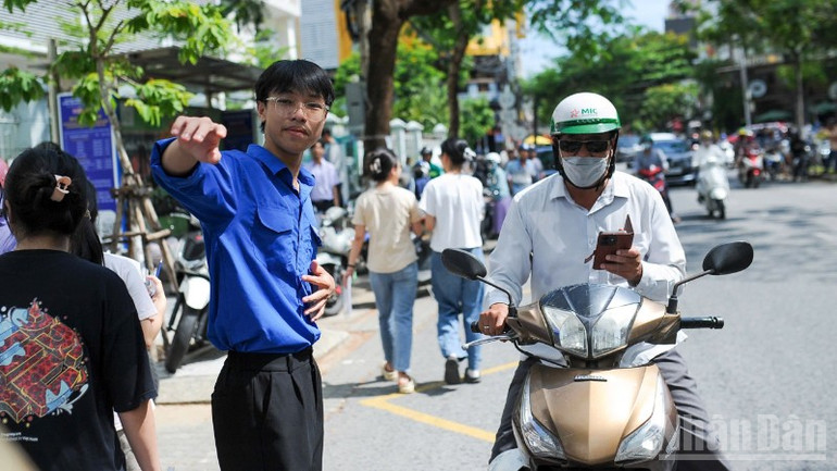 Tình nguyện viên hỗ trợ phân luồng đảm bảo an toàn giao thông tại điểm thi. ndo_br_71d3114a-2bf7-4d84-99db-cb7a18e20ead-2214.jpg