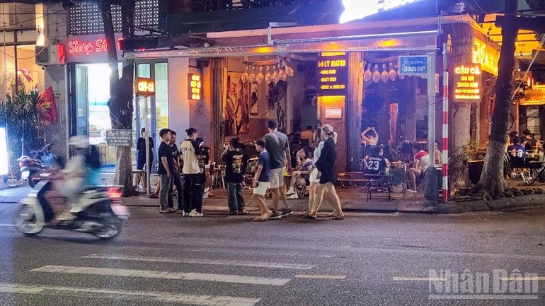 Một gia đình người nước ngoài và cả nhân viên quán phải xuống lòng đường, "nhường" vỉa hè cho việc buôn bán. ndo_br_z6857856983281-bd3adc183d263b1dd645a86c3953ddc1-6424.jpg