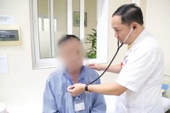 Bác sĩ thăm khám cho bệnh nhân sau phẫu thuật.