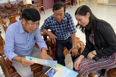 Nhân viên Bảo hiểm xã hội tỉnh Bình Phước tư vấn những lợi ích khi tham gia bảo hiểm xã hội tự nguyện cho người dân. (Ảnh: ĐỖ THOA)