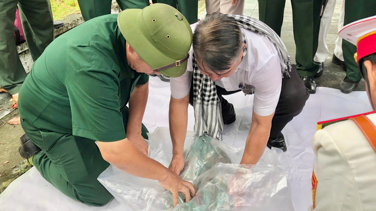 Đại diện các cơ quan chức năng thực hiện các bước cất bốc hài cốt liệt sĩ. img-3388.jpg