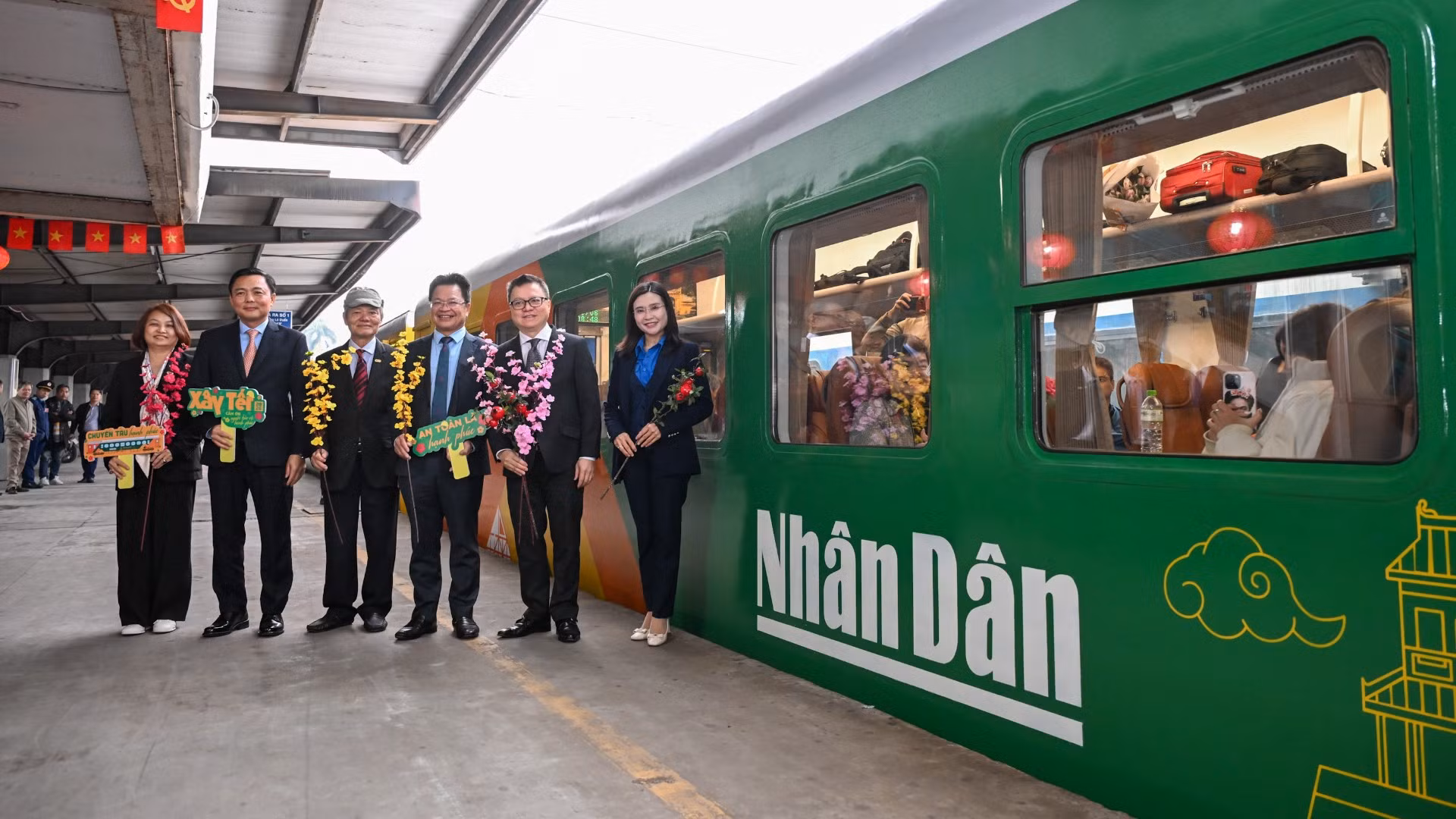 Các đại biểu tại "Chuyến tàu hạnh phúc", chuyến tàu đặc biệt có in logo của Báo Nhân Dân.