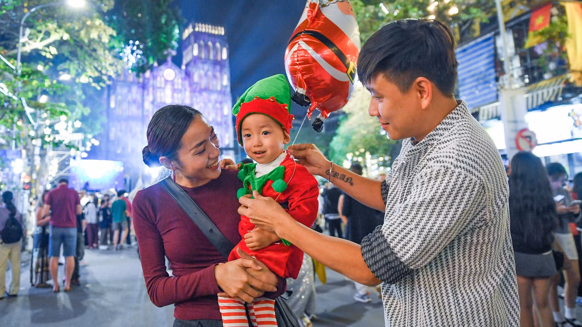 Gia đình đưa trẻ nhỏ đi đón Noel tại Nhà thờ Lớn.