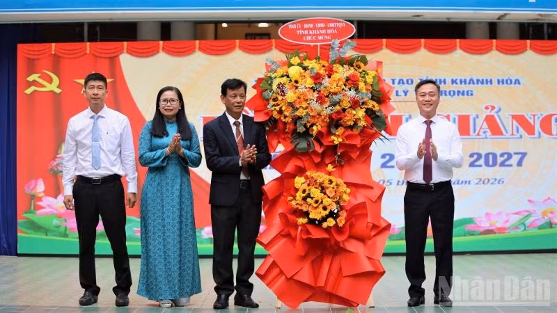 Chủ tịch Ủy ban nhân dân tỉnh Nguyễn Việt Hùng tặng hoa chúc mừng Trường trung học phổ thông Lý Tự Trọng nhân ngày khai giảng năm học mới. (Ảnh: VŨ TÂN)