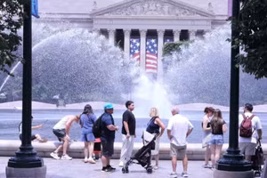 Du khách tránh nắng nóng bên đài phun nước tại khu vực National Mall (Quảng trường Quốc gia) ở thủ đô Washington D.C. (Ảnh: TTXVN)