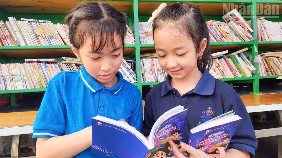 Các em học sinh rất hào hứng khi được tặng sách thiếu nhi “Bí mật quả cầu tím”.