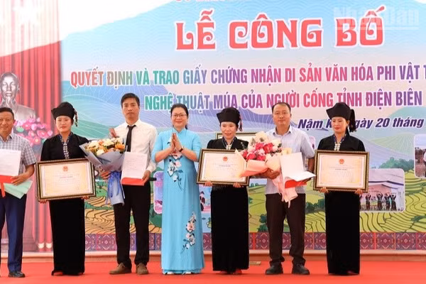 Đồng chí Nguyễn Thị Thanh Chuyên, Phó Giám đốc Sở Văn hóa, Thể thao và Du lịch Điện Biên trao Bằng Công nhận Di sản văn hóa phi vật thể quốc gia cho Nghệ thuật múa của người Cống cho nhân dân dân tộc Cống xã Nậm Kè. (Ảnh: LÊ LAN)
