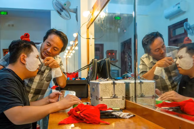Nghệ sĩ Ưu tú Mai Ngọc Nhân góp ý với diễn viên trong lúc hóa trang vẽ mặt tuồng chuẩn bị biểu diễn. (Ảnh: MỸ HÀ)