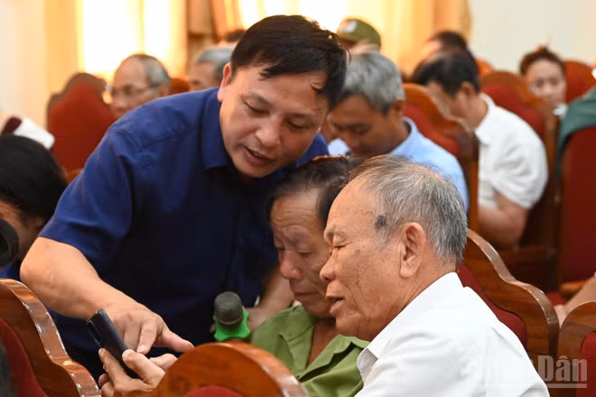 Cán bộ Trung tâm Khoa học, Công nghệ và Chuyển đổi số Hà Tĩnh hướng dẫn người dân cài đặt và sử dụng phần mềm i-HaTinh. (Ảnh: NGÔ TUẤN)