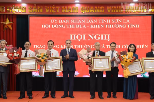 Đồng chí Nguyễn Đình Việt, Chủ tịch Ủy ban nhân dân tỉnh Sơn La và Phan Văn Hùng, Phó trưởng Ban Thi đua-Khen thưởng Trung ương trao Huân chương Lao động hạng Nhì cho các cá nhân. (Ảnh: QUỐC TUẤN)