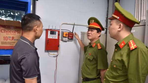 Cảnh sát Phòng cháy, chữa cháy và cứu nạn, cứu hộ hướng dẫn người dân sử dụng thiết bị báo cháy. (Ảnh: C07)