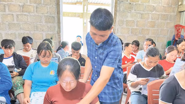 Cán bộ xã Cao Minh hướng dẫn người dân thôn Cốc Lải sử dụng các ứng dụng AI trên điện thoại thông minh (Ảnh ANH TUẤN) 