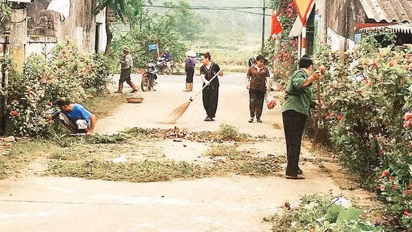Người dân xã Suối Hai cùng nhau làm sạch đường làng ngõ xóm (Ảnh HỒNG LÊ)