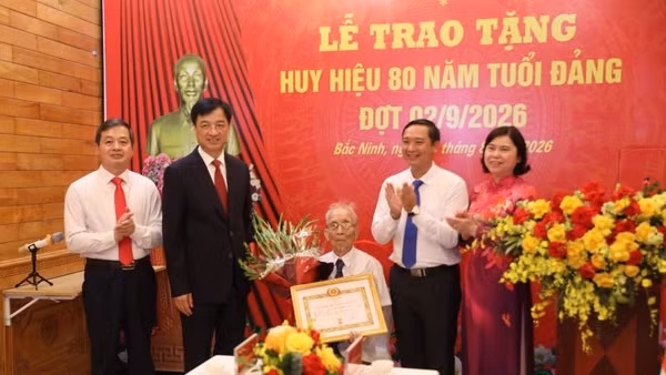 Đồng chí Nguyễn Duy Ngọc (thứ 2, trái sang) trao tặng Huy hiệu 80 năm tuổi Đảng cho đảng viên Nguyễn Thanh Mậu. (Ảnh: DL)
