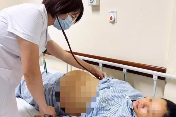 Bác sĩ Viện Y học nhiệt đới Bạch Mai thăm khám cho sản phụ bị viêm gan B đang điều trị. (Ảnh: BVCC)