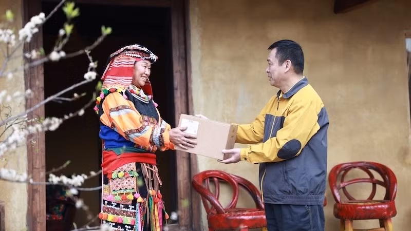 Nhân viên bưu điện chuyển phát bưu phẩm đến tay người dân.