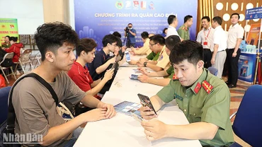 Chiến sĩ trẻ lực lượng công an thành phố Hà Nội hỗ trợ người dân kích hoạt định danh điện tử tại chương trình ra quân.