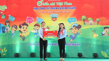 Đồng chí Nguyễn Phạm Duy Trang, Bí thư Trung ương Đoàn, Chủ tịch Hội đồng Đội Trung ương (bên phải) trao biển tượng trưng công trình "Không gian vui chơi và đọc sách cho em" tặng đại diện Hội đồng Đội tỉnh Bà Rịa-Vũng Tàu. 