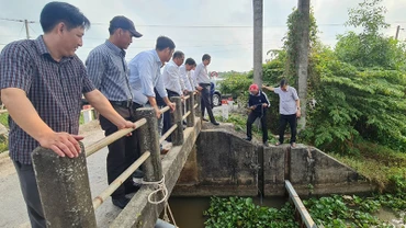 Ông Trương Cảnh Tuyên, Phó Chủ tịch thường trực Ủy ban nhân dân tỉnh Hậu Giang (bìa phải) kiểm tra nồng độ mặn tại cống Hóc Pó, xã Lương Nghĩa