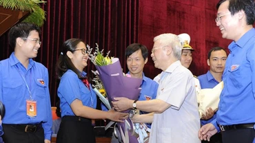 Tổng Bí thư, Chủ tịch nước Nguyễn Phú Trọng tặng hoa các đảng viên trẻ tiêu biểu tại buổi gặp mặt. (Ảnh: ĐĂNG KHOA)