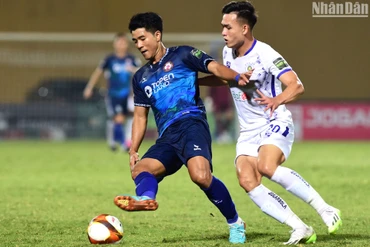 Hà Đức Chinh (áo xanh, Bình Định) bị ngăn chặn bởi Bùi Hoàng Việt Anh. (Ảnh: TRẦN HẢI)
