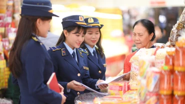 Công chức Quản lý thị trường hướng dẫn các hộ kinh doanh chấp hành quy định pháp luật về kinh doanh, buôn bán.