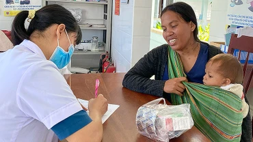 Cán bộ y tế khám, tư vấn sức khỏe cho bà mẹ và trẻ em vùng cao.