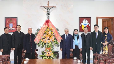 Đồng chí Đỗ Văn Chiến (thứ 5 từ phải sang) tặng hoa chúc mừng Tổng Giám mục Giuse Vũ Văn Thiên (thứ 3 từ trái sang).