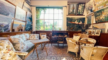 Xưởng vẽ với bộ ghế salon bọc vải hoa, cùng bức tường treo kín bản sao của những tranh gốc gây ấn tượng mạnh với bất kể ai khi bước vào căn phòng.