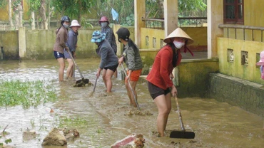Giáo viên các trường học ở huyện Lệ Thủy dọn bùn, vệ sinh trường lớp để học sinh đi học trở lại.