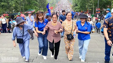Tình nguyện viên hỗ trợ du khách cao tuổi trên đường lên Đền Hùng. 
