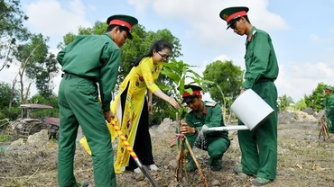 Cán bộ, chiến sĩ Trung đoàn Bộ binh 893 và thanh niên, phụ nữ trên địa bàn đơn vị đóng quân cùng tham gia trồng cây xanh. 