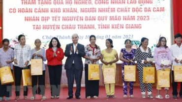 Chủ tịch nước Nguyễn Xuân Phúc tặng quà cho hộ nghèo, công nhân lao động có hoàn cảnh khó khăn, người nhiễm chất độc da cam trên địa bàn. (Ảnh: Thống Nhất/TTXVN)