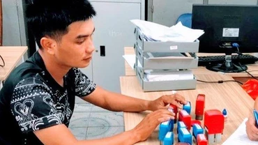 Đối tượng Phạm Đình Hậu cùng số con dấu giả bị thu giữ.
