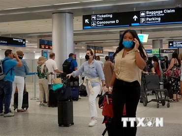 Hành khách đeo khẩu trang phòng lây nhiễm Covid-19 tại sân bay ở Miami, Florida, Mỹ. (Ảnh: AFP/TTXVN)